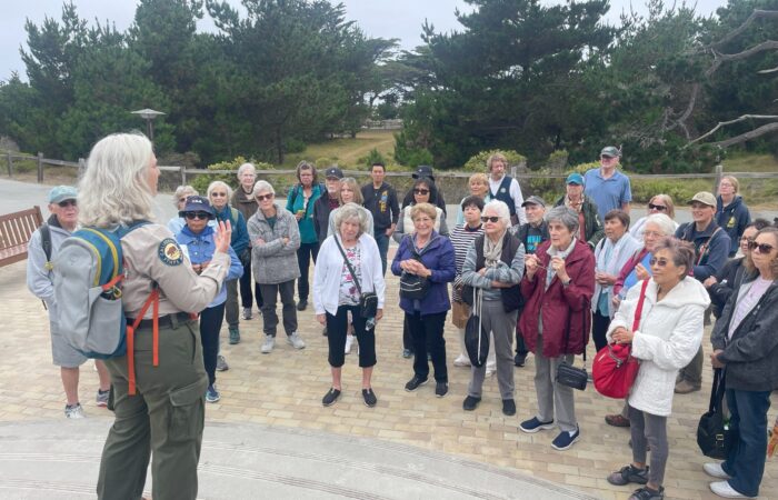 Group of seniors from Asilomar Great getaway listening to park interpreter