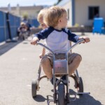 preschoolers outside on a tricycles